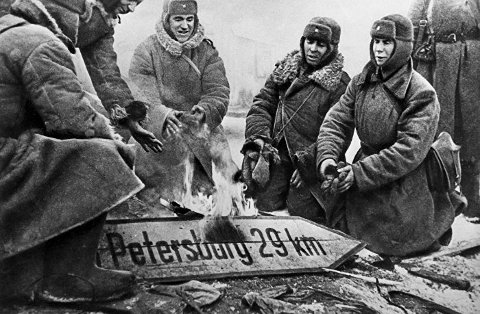 Солдаты Советской армии сжигают немецкий дорожный указатель, январь 1944 года