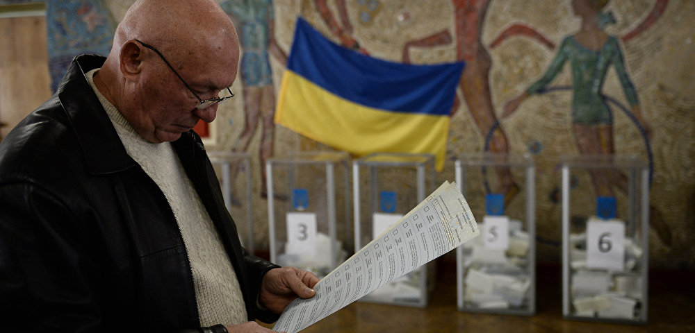 Мужчина с бюллетенями во время голосования на выборах