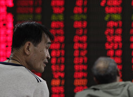 Инвесторы следят за ценами на акции в брокерском доме в Пекине