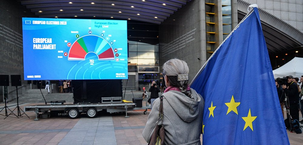 Женщина с флагом ЕС у штаб-квартиры Европпарламента в Брюсселе