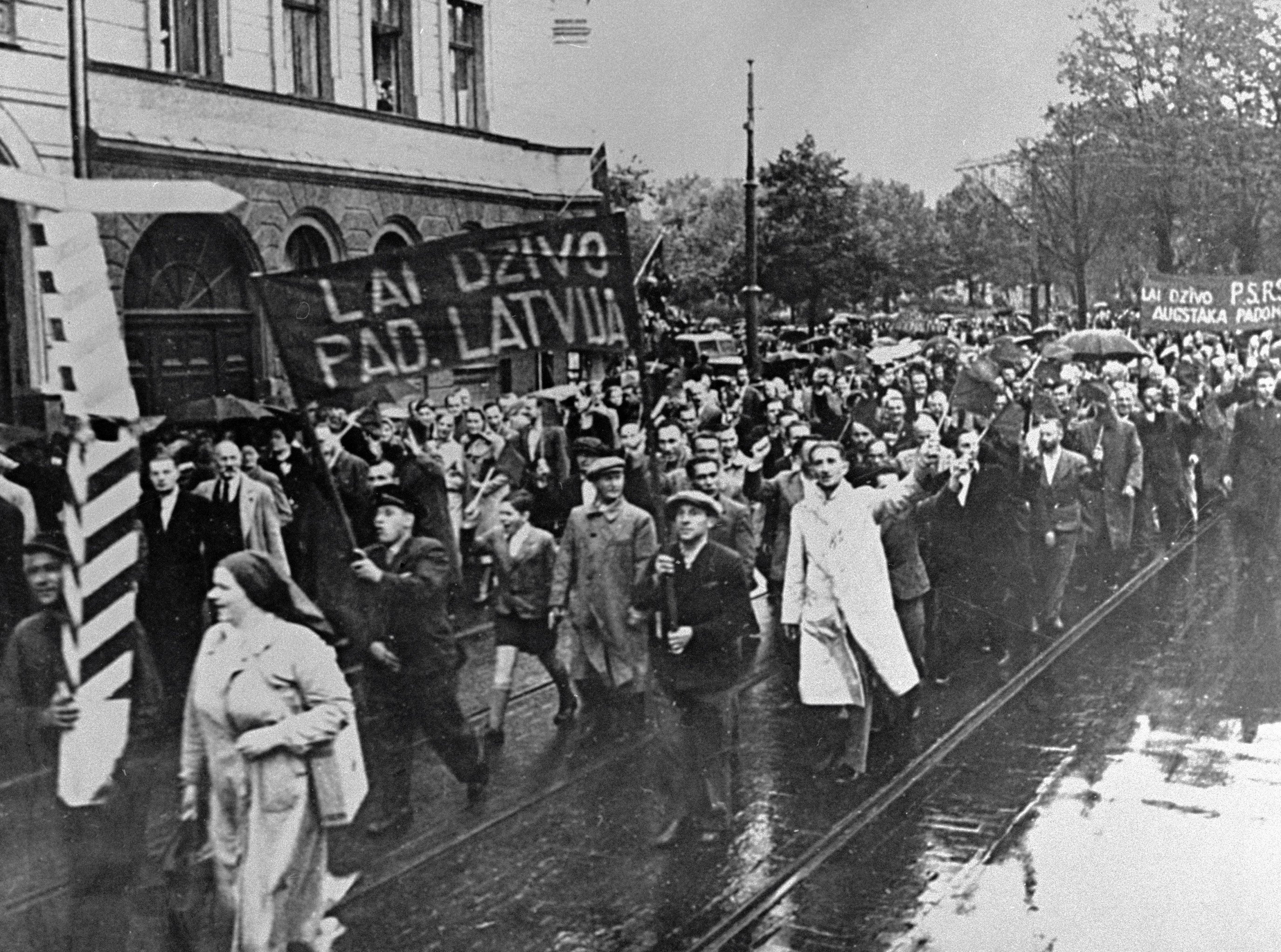 Демонстранты, идущие по улицам Риги, несут транспаранты с надписью "Да здравствует Советская Латвия", 1940 год