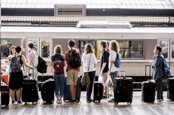 Молодые люди на станции железнодорожного вокзала, архивное фото